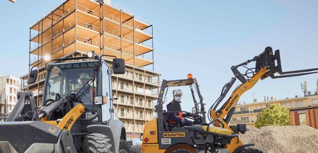 Ein Kiloutou Radlader und ein Minibagger im Einsatz auf einer Baustelle; ein Beispiel für die vielseitigen Erdbewegungslösungen der Marke.